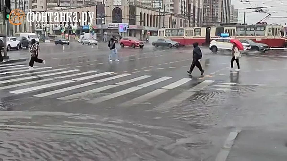 После многочасового дождя на углу Коломяжского проспекта и проспекта Испытателей вода залила проезжую часть и тротуары